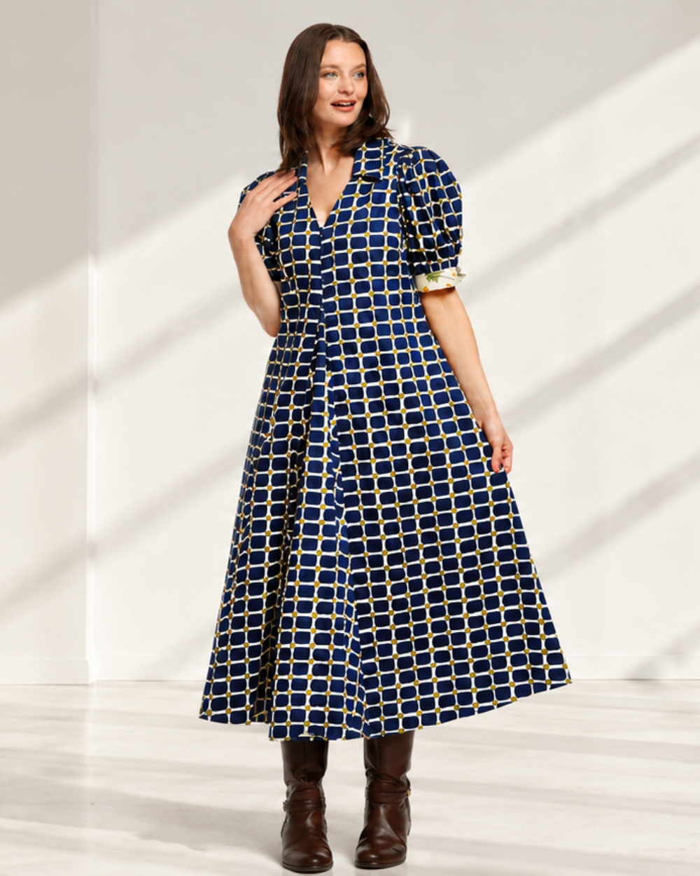 Model wearing a navy windowpane-check dress with puff sleeves in a bright white room